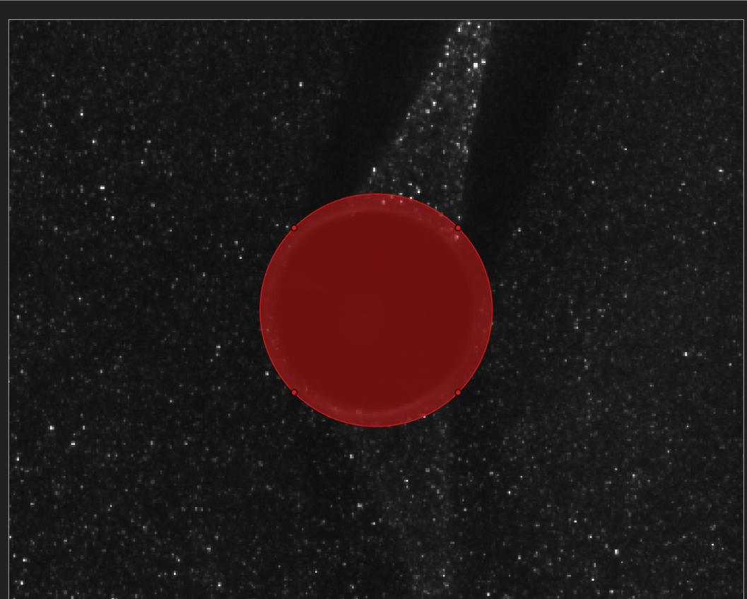 A red circular mask covering the dark cylindrical rod