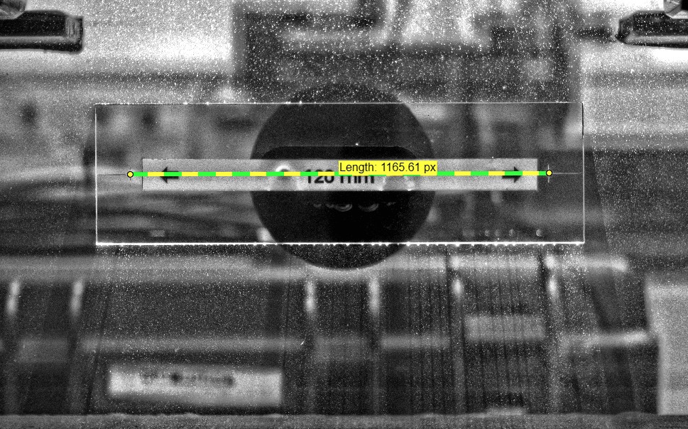A reference line drawn across a calibration target of known size; a label reports its length in pixels (1165.61 px) for a real distance of 120 mm